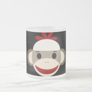 Gulligt le sock monkeyansikte på röd svart frostad glasmugg