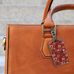 Gult orange blommönster mörk röd bagagetagg bagagebricka