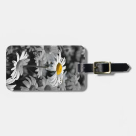 Gultens daisy i ett hav av svarta och vita daisy. bagagebricka