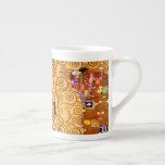 Gustav Klimt Livets träd Benporslin Mugg<br><div class="desc">Bone China Mugg med Gustav Klimts mural The Livets träd,  The Stoclet Frieze (1905-1911). Den består av tre mosaiker: Förväntningen,  Knight och Embrace. En vacker kvinna,  ett gyllene träd och två älskare i ett omslag framställs. En underbar gåva till fläkt av Art nouveau och österrikisk konst.</div>