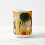 Gustav Klimt the Kiss Kaffemugg<br><div class="desc">Kaffe Mugg med Gustav Klimts oljemålning med guld löv Kiss (1908). En man och kvinna,  som bär briljant gyllene färg,  tar gärna till sig och kysser i ett fält av blommor. En underbar gåva till fläkt av Art nouveau och österrikisk konst.</div>