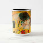 Gustav Klimt the Kiss Mugg<br><div class="desc">Kaffe Mugg med Gustav Klimts oljemålning med guld löv Kiss (1908). En man och kvinna,  som bär briljant gyllene färg,  tar gärna till sig och kysser i ett fält av blommor. En underbar gåva till fläkt av Art nouveau och österrikisk konst.</div>