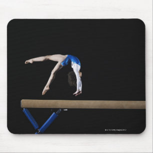 Gymnast (9-10) som bläddrar på balansbommen, sid musmatta