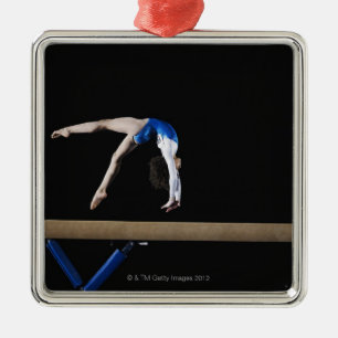 Gymnast (9-10) som bläddrar på balansbommen, sida julgransprydnad metall