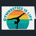 Gymnastiken är ett levande solnedgångskort hälsningskort<br><div class="desc">Gymnastiken är Life. Tur gymnastiskt kort med vacker färgstark bakgrund bakom en kvinna som gör ett söt handställ med spalterna.</div>