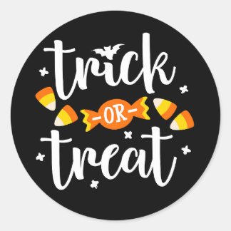 Halloween-textdesign med trick or treat och godis runt klistermärke