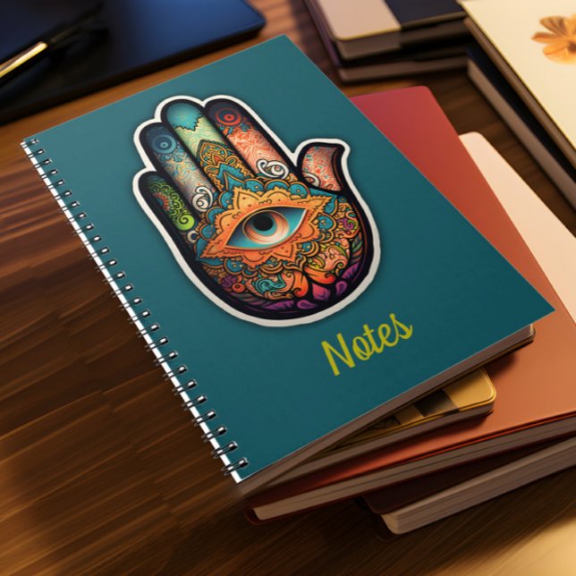 Hamsa Hand Spiral bärbar dator Anteckningsbok (A pile of notebooks lies on a desk)