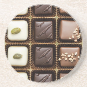 Handgjord lyxig choklad i en boxas underlägg sandsten