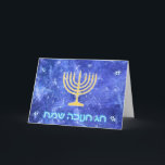 Hanukkah Snowstorm Menorah Helgkort<br><div class="desc">En glödande menorah guld Hanukkah och "Chag Chanukkah Sameach" (Lycklig Hanukkah) i glödande blå och vit text som läggs ovanpå en blå och vit fraktalbild som påminner om snöflingor i en storm.</div>