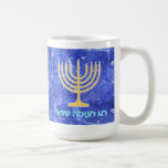 Hanukkah Snowstorm Menorah Kaffemugg<br><div class="desc">En glödande guld Hanukkah-menorah och en hebreisk text där det står "Chag Chanukkah Sameach" (Lycklig Hanukkkah) i glödande blå och vit text som läggs ovanpå en blå och vit fraktalbild som påminner om snöflingor i en storm. Lägg till ytterligare text.</div>
