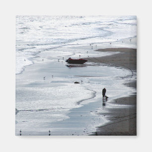 Havsvatten som kommer till stranden vid dusk magnet
