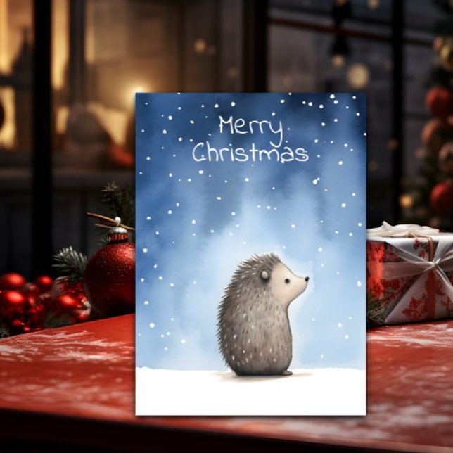 Hedgehog jul julkort (A Christmas card with a cute illustration of a hedgehog is shown on a table with decorations around )