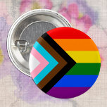 HGBTQ & Pride - Flagga för regnbågsförlopp Knapp<br><div class="desc">Knapp: Regnbågens Flagga och "Progress"-variationen lägger till en schevon längs hosten med svart, brun, ljusblå, rosa och vitt rand för att föra dessa samhällen (marginaliserade människor i färg, transindivider och de som lever med hiv/AIDS och de som har varit borttappad) i förgrunden, "pilen pekar på högerna för att visa framåtskridande...</div>
