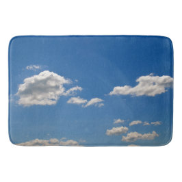 Himlar är blått och vita moln passerar förbi badrumsmatta