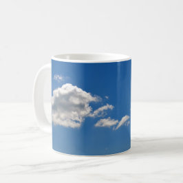 Himlar är blått och vita moln passerar förbi kaffemugg