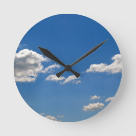 Himlar är blått och vita moln passerar förbi rund klocka