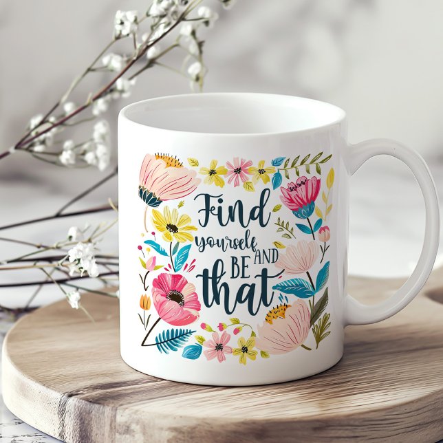 "Hitta dig själv och var den" Blommigten inspirera Kaffemugg ("Find Yourself and Be That" Floral Inspirational Coffee Mug on a boho kitchen table.)