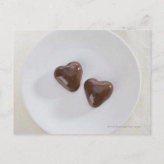 Hjärtformade chokladkanaler på en platta vykort
