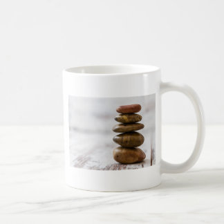 Hög av mörkfärgadstenar på vitbakgrund kaffemugg