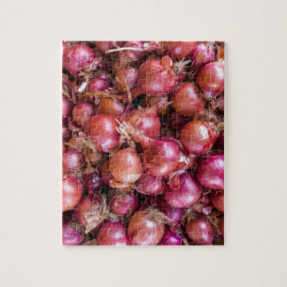 Högen av röda lökar marknadsför på pussel