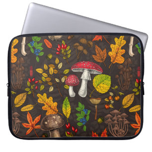 Höjd, löv, nöt och bär på mörk laptop fodral