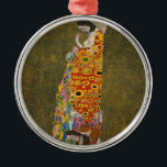 Hope II av Gustav Klimt, Vintage Art nouveau Julgransprydnad Metall<br><div class="desc">Hope II (1907/08) of Gustav Klimt är en vintage Victorian Era Symbolism bra art-målning som föreställer en gravid dam som tittar ner över sin stora buk mot ett mänskligt skalle. Det finns tre kvinnor nära hennes fötter som är vävda i hennes bergarts hårda mönster. Kvinnan har exponerat bröst och får...</div>