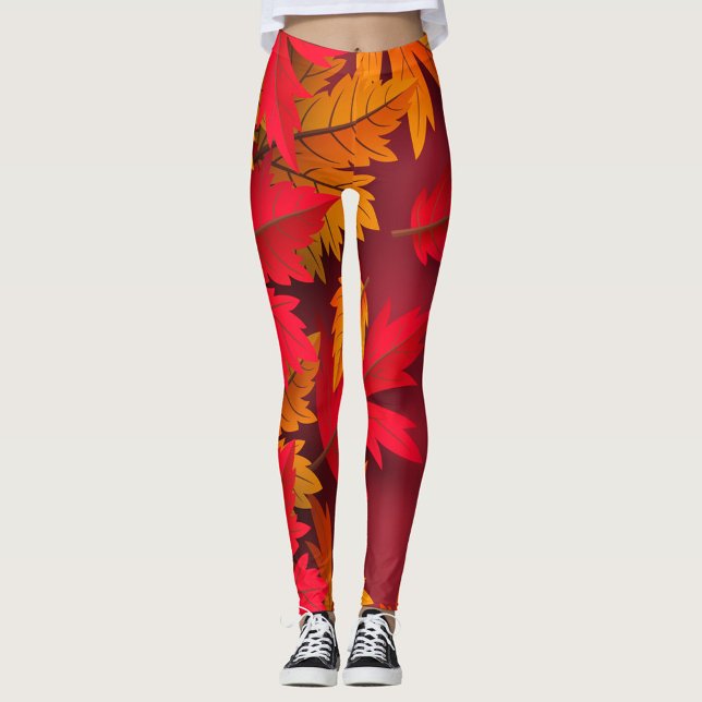 Höst Leggings ( A model showcases vibrant leggings adorned with autumn leaves in shades of red and orange. )