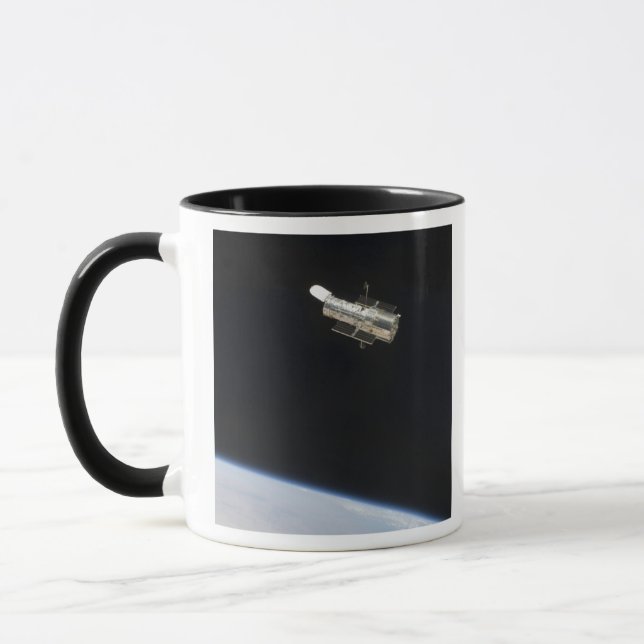 Hubble Space Telescope i omloppsbana ovanför jord  Mugg (Vänster)
