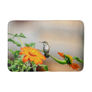 Hummingbird på en blommar anläggning badrumsmatta