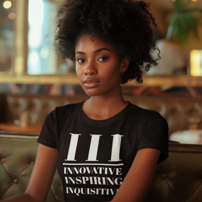 III - Innovativ, inspirerande, inkvisiv T Shirt (Young black woman wears a "III: Innovative, Inspiring, Inquisitive" black t-shirt.)