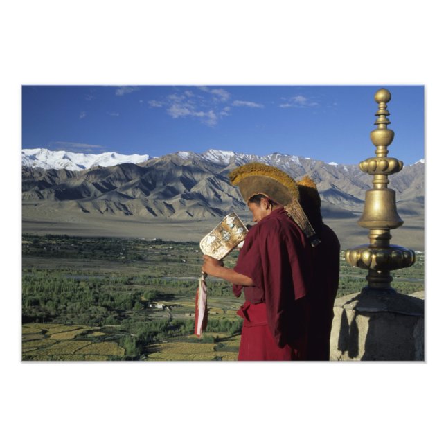 Indien, Ladakh, Thikse. Buddhist munk blåser Fototryck (Framsidan)
