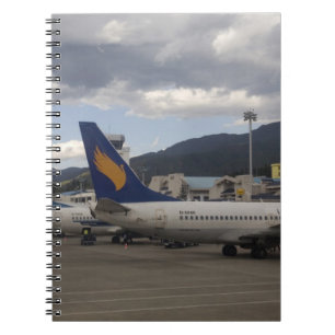 Inhemska kinesiska jetflygplan uppradade vid anteckningsbok med spiral