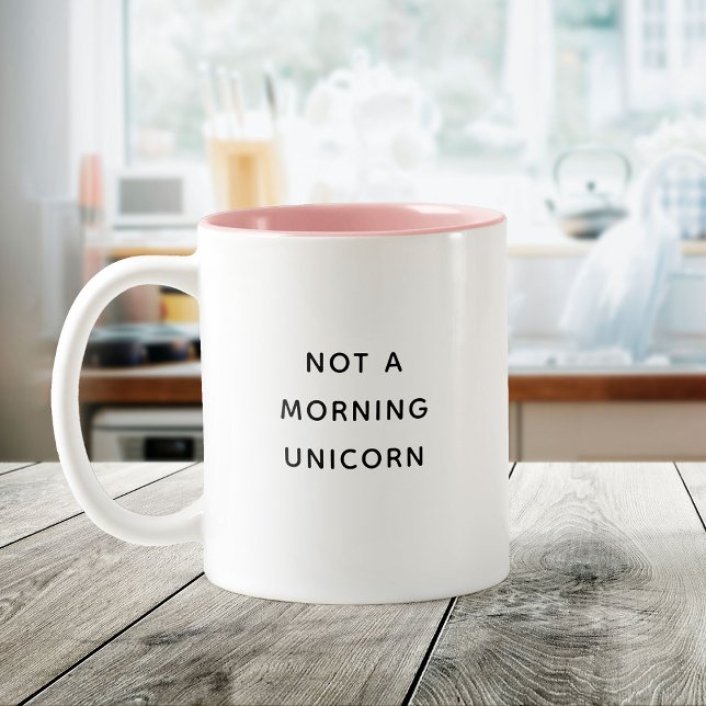 Inte en morgonUnicorn Funny Cute Trendig Citat Två-Tonad Mugg (White mug with pink interior on a wooden table, featuring text "Not a morning unicorn.)