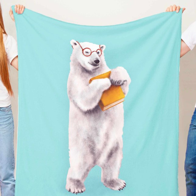 Isbjörn Bokälskare Nörd Fleecefilt (blue blanket with a cute smiling polar bear with eyeglasses holding a yellow book, held in hands)