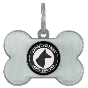Jag är döv svart hund med spetsade öron och slutna ID-bricka husdjur