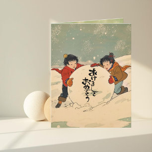 Japanska barn som rullar en stor snöboll kort