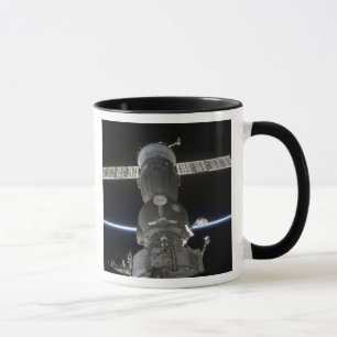Jord limb skär ett Soyuz rymdskepp Mugg