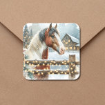 Jul om Brown och White Horse Land Fyrkantigt Klistermärke<br><div class="desc">Söt julklistermärken för festlig personlig. En söt brun och vit häst som står bakom ett gammalt skorstenshus med snöbakgrund och vintage gammal röd lada. Den snö-fyllda stängslet är försedd med belyst julklapp ljus till ge och en varm känsla för julklistermärken i land för dina julkort.</div>