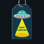 Jul UFO Ho Ho Alien flight saucer Anpassningsbar Presentetikett<br><div class="desc">Den här uppsättningen Juletiketter i fantastisk har en digital konst av en utomjordisk rymdfarkost som dekoreras med den ljusa färgaden Juli ljus. Inuti UFO tittar man ut genom fönstret finns det en grönt utomjording med svart ögon som bär en festlig julhatt. Det finns en ljuskon från flygsåkaren. Skuggan av ett...</div>