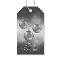 Julgranskulor i silvergrått på röd bokeh