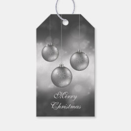 Julgranskulor i silvergrått på röd bokeh presentetikett