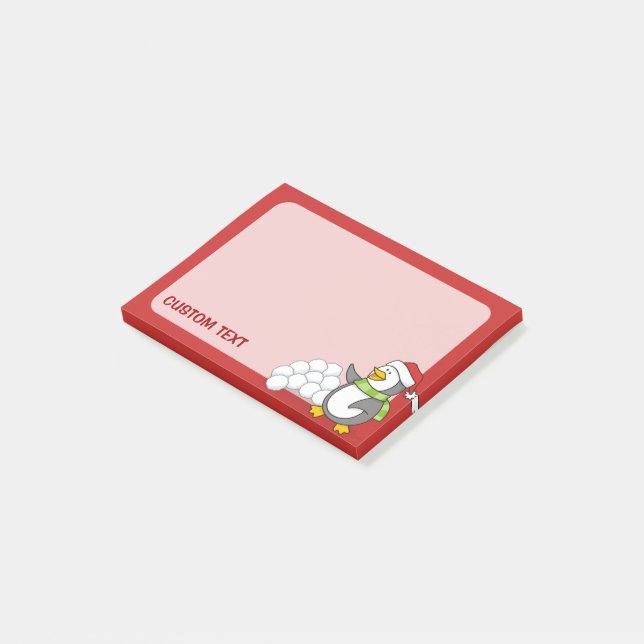 Julpenguin med snö bollar som viftar post-it block (Vinklad)