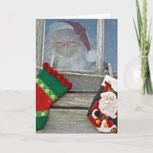 Jultomten i kabinfönster med snöflingor kort