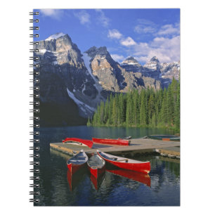 Kanada, Alberta, Moraine Lake. Röda kanoter väntar Anteckningsbok Med Spiral