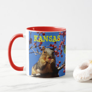Kansas Squirrel äter en röd Berry Coffee Mugg