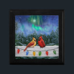 Kardinaler och julafton Ljus Winter Snö Minnesask<br><div class="desc">Norra Red Cardinals perch på ett stängsel som täcktes av snö och som ströks med julen ljus. Snöflingor faller från himlar nattetid och täcker den omgivande skogen med en vintertäcke av vitt.</div>