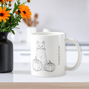 Katt med pumpor med minimal avverkning av konst oc kaffemugg