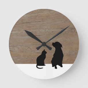Katt- och hundillustrationsilhouettes på trä rund klocka