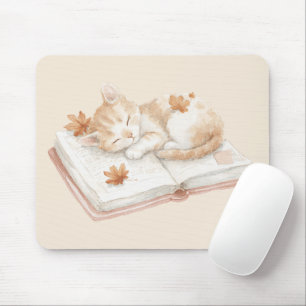 Katt som sover på en bok musmatta