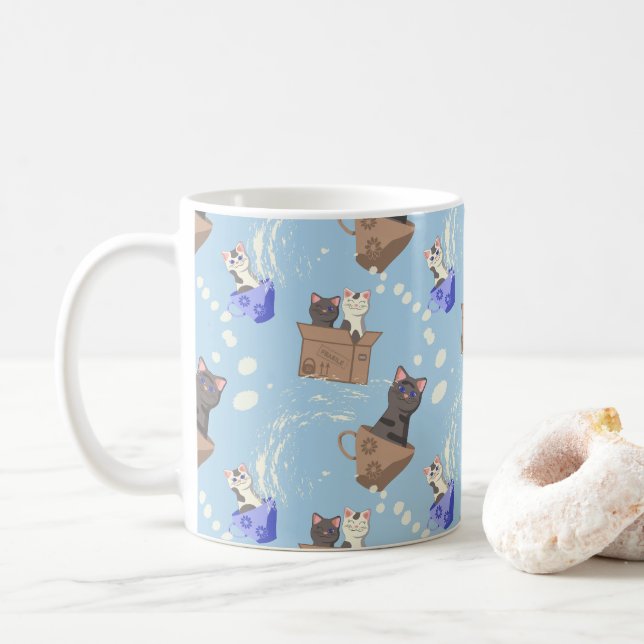 Katter i låda och mjölk droppar i blått kaffemugg (Med munk)